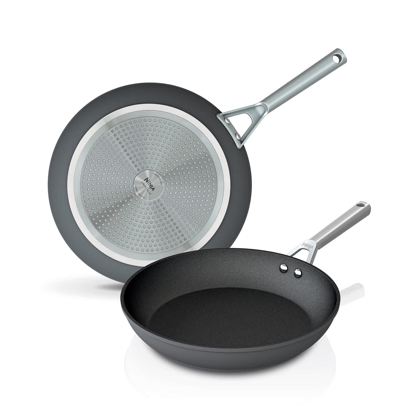 Two Ninja black frying pans, one showing the cooking surface and the other showing the silver induction base.